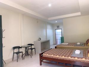 Habitación con 2 camas, mesa y sillas en Sabye~Sabye en Ko Tao