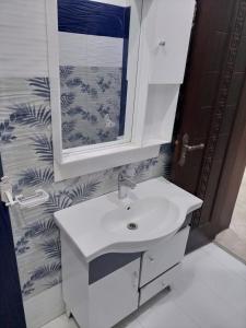 a bathroom with a white sink and a mirror at Furnished Private Ground Floor - Pasha House in Lahore