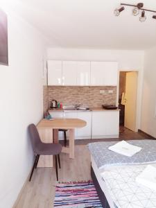 eine kleine Küche mit einem Holztisch und einem Stuhl in der Unterkunft Dubrovnik Sun Apartment in Dubrovnik