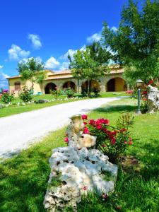 a rock garden in front of a house with flowers at Saturnia Pian Di Cataverna in Saturnia