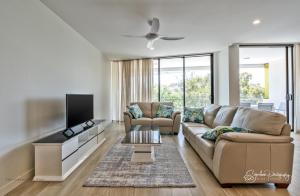 uma sala de estar com um sofá e uma televisão de ecrã plano em RIVERFRONT BREEZE @ The Cosmopolitan Unit10307 em Maroochydore