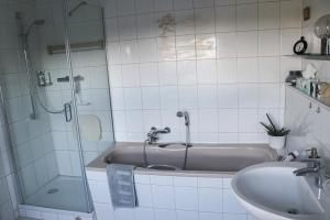 a bathroom with a shower and a sink and a tub at Deine-Eifel-Ferienwohnung in Feusdorf