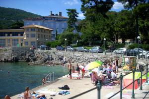 a group of people on a beach near the water at Apartments by the sea Lovran, Opatija - 14180 in Lovran