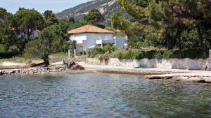 a house on the shore of a body of water at Apartment Barbat 16723b in Rab