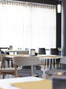 a classroom with tables and chairs and a window at Master Hotel Reggio Emilia in Reggio Emilia