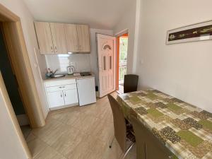 a kitchen with a table with chairs and a table and a room at Villa nad Morem in Podaca