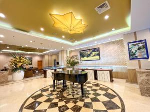 a lobby with a piano on a checkered floor at Sapaly Lao Cai City Hotel in Lao Cai