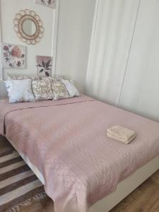 un letto con coperta rosa e cuscini in una camera da letto di Cozy Hut with the included Hot Tub-Prime Rentals 