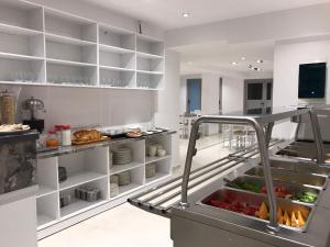 a kitchen with a bunch of food on shelves at Ventus Hotel in Ksamil