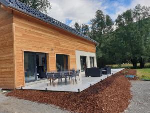 patio ze stołem i krzesłami obok budynku w obiekcie Villa Nomy w mieście Grandes Sables