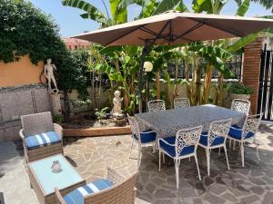 - une table et des chaises avec un parasol sur la terrasse dans l'établissement Residence Don Turi, à Villafranca Tirrena