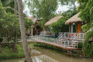 a bridge over a river in front of houses at Karaboon Wellness in Phitsanulok