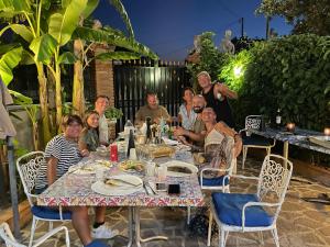 un groupe de personnes assises à une table dans l'établissement Residence Don Turi, à Villafranca Tirrena