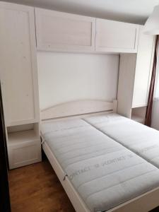 uma cama num quarto com armários brancos em Anna's em Sibiu