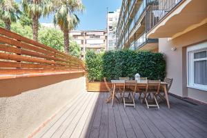 uma mesa e cadeiras de madeira num deque de madeira em BBarcelona Sagrada Familia Flats em Barcelona