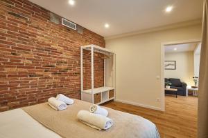 Un dormitorio con una pared de ladrillo y una cama en BBarcelona Sagrada Familia Flats, en Barcelona