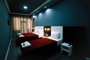 Habitación con 2 camas en rojo y blanco en Hotel Rero, en Kutaisi