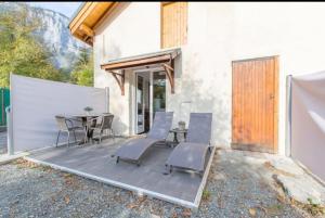 patio ze stołem i krzesłami oraz budynek w obiekcie Studio La Cabane Centre Ville w mieście Le Bourg-dʼOisans