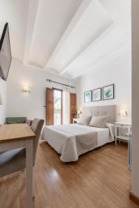 Habitación blanca con cama grande y escritorio. en Hotel La Sitja - Adults only, en Benisoda