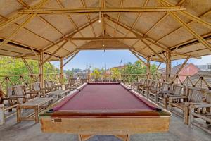 a pool table in a pavilion with chairs at OYO 91522 Candi Gebang Guesthouse in Seturan