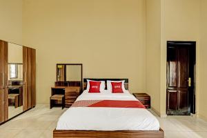 a bedroom with a large bed with red pillows at OYO 91522 Candi Gebang Guesthouse in Seturan