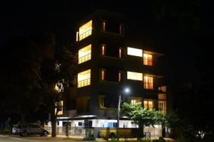 a tall building with lit windows at night at The Vihar service Apartment in Mysore