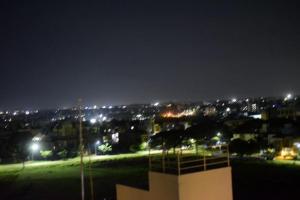 uitzicht op een stad 's nachts met verlichting bij The Vihar service Apartment in Mysore