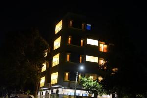 un edificio alto con ventanas iluminadas por la noche en The Vihar service Apartment, en Mysore