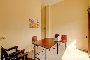 - une salle de conférence avec une table et un ordinateur portable dans l'établissement OYO 91522 Candi Gebang Guesthouse, à Seturan