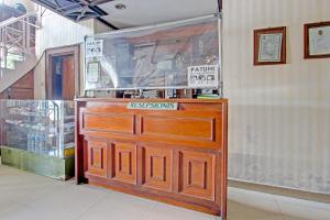 a wooden door with a sign on it in a store at OYO 91525 Hotel Bugisan in Ngabean