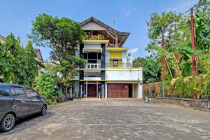 a house with a car parked in front of it at OYO 91522 Candi Gebang Guesthouse in Seturan