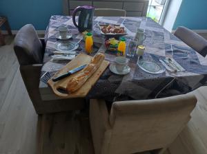 ein Tisch mit einem Tischtuch drauf mit Essen drauf in der Unterkunft Chambre chez l'habitant " Les Ritières " in Plomeur