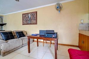 a living room with a table with a laptop on it at OYO 91547 Graha Hermawan Guest House Syariah in Bandung