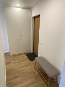 a small room with a bench and a door at ETG Apartment in Mažeikiai