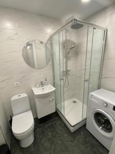 a bathroom with a toilet and a shower and a sink at ETG Apartment in Mažeikiai