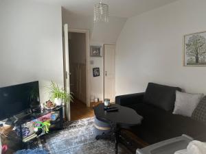 ロンドンにあるA lovely guest room in West Londonの黒いソファとテーブルのあるリビングルーム