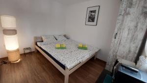 a small bedroom with a bed with two dishes on it at Vila Largo in Donja Mala