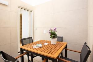 uma mesa de jantar com cadeiras e um vaso de flores em DonCarlo Suite Relais - Free Parking-parcheggio gratuito em Lecce