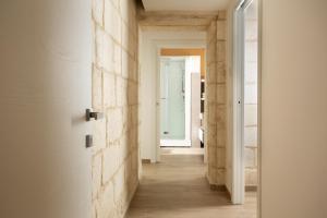 un corridoio con pareti bianche e pavimenti in legno di DonCarlo Suite Relais - Free Parking-parcheggio gratuito a Lecce