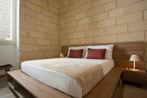 um quarto com uma grande cama branca e 2 almofadas vermelhas em DonCarlo Suite Relais - Free Parking-parcheggio gratuito em Lecce