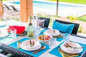 uma mesa com pratos de comida e uma garrafa de champanhe em Villa del Nord em Sa Pobla