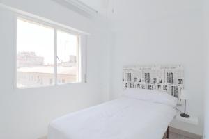 マラガにあるC85 - Brand New 3 Bedroom Apartment by the Centerの白いベッドルーム(ベッド1台、窓付)