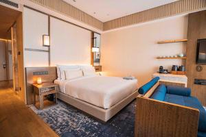 上海市にあるThe Anandi Hotel and SPA - Luxury Healing Hotel for Wellbeingのベッドルーム(大型ベッド1台、ソファ付)