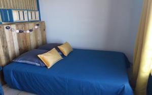 a bedroom with a bed with blue sheets and pillows at Le Bel Horizon in Le Tampon