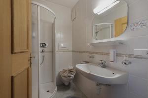 Baño blanco con lavabo y aseo en Garni Ziernheld, en Malles Venosta