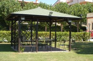 a gazebo with a table and chairs in a park at Albergo el Rancho in Bevagna