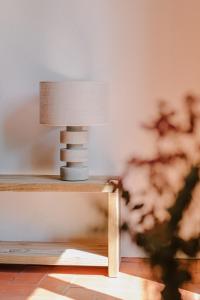 a table with a lamp on a wooden shelf at Flateli Santa Clara 11 in Girona