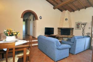 een woonkamer met 2 blauwe stoelen en een open haard bij Villa Alice in Chiusi