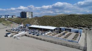 un restaurant sur la plage à côté d'une plage de sable dans l'établissement Costa, à Zandvoort