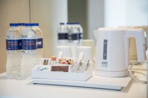 a coffee maker and bottles of water on a counter at Holiday Inn Express Jakarta International Expo, an IHG Hotel in Jakarta